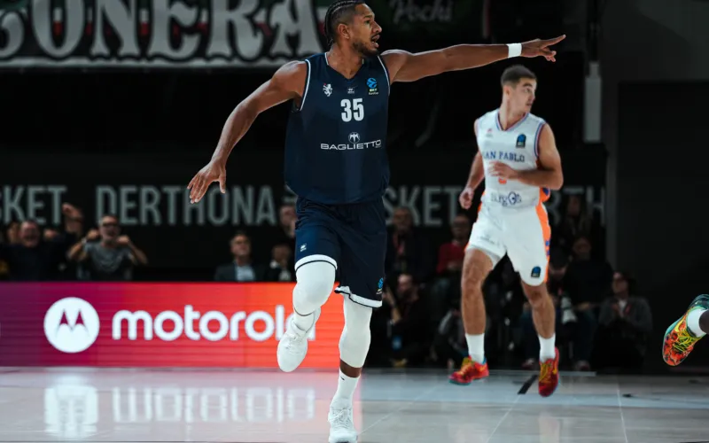 Un giocatore del Derthona con la maglia numero 35 corre sul parquet e indica una direzione, mentre un avversario è sullo sfondo.