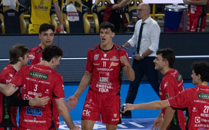 Immagine di archivio di una partita di volleyball con giocatori in divisa rossa che festeggiano.