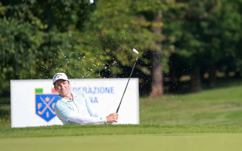 Golfista che colpisce la pallina su un campo da golf durante una competizione.